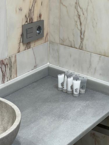 un montón de tazas sentadas en un mostrador en un baño en APARTAMENTO TURÍSTICO SAN NICOLAS, en Avilés