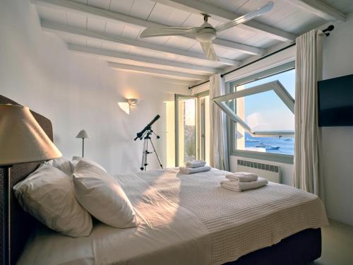 1 dormitorio con 1 cama blanca y ventana en Cordelia Villa en Psarou