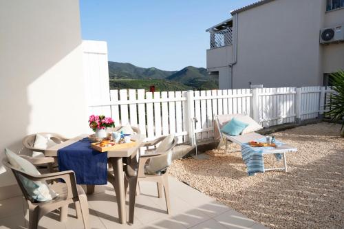 a patio with a table and chairs on a balcony at Dòmo#14 - Villino Piscina, Giardino e Parcheggio in Viddalba