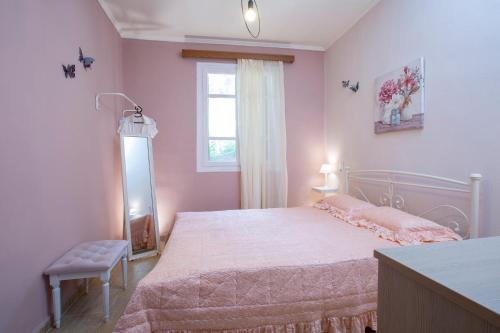 um quarto rosa com uma cama e uma janela em Elena’s House Sivota Lefkadas em Sivota