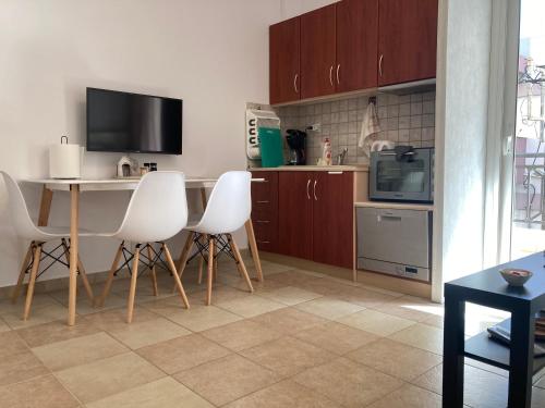 eine Küche mit einem Tisch und 4 weißen Stühlen in der Unterkunft Minion in Alexandroupoli