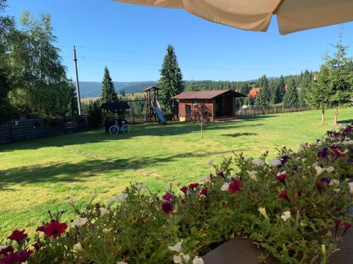 uma vista para um pátio com um parque infantil em Pensiunea Vis Alpin Belis em Beliş