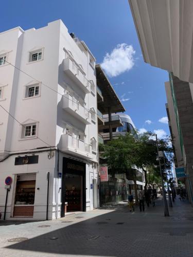 un bâtiment blanc sur le côté d'une rue dans l'établissement Apartamento en C/ León y Castillo (C/ Real) Centro de Arrecife, à Arrecife