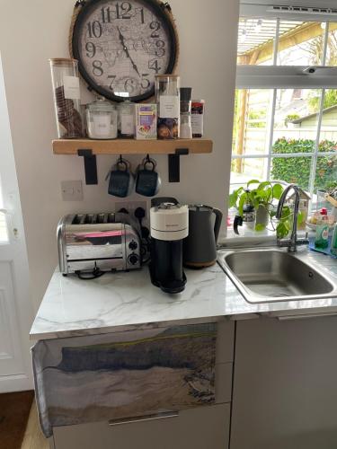a kitchen counter with a clock above a sink at Roseberry Loft perfect for Wilton site in Nunthorpe