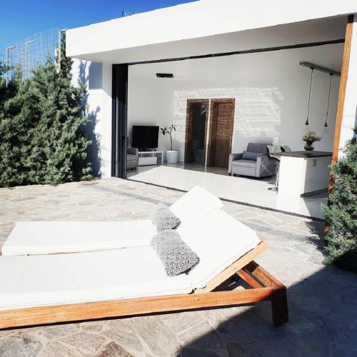 a teddy bear sitting on a bench in a living room at One Bedroom Pool House by Olivujoj in Anavissos