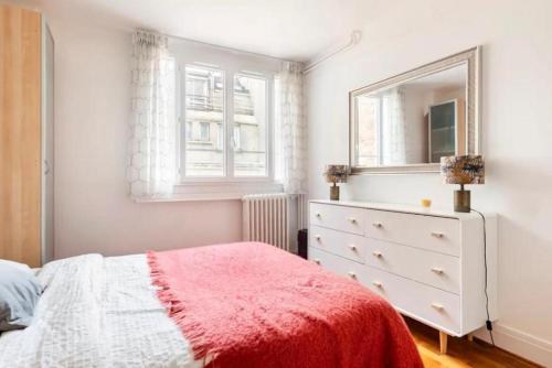 a bedroom with a bed and a dresser and a mirror at Spacious Moderne & Design appartement 16em Arrondissement in Paris