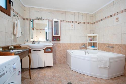 y baño con bañera, lavamanos y bañera. en Elena’s House Sivota Lefkadas, en Sivota