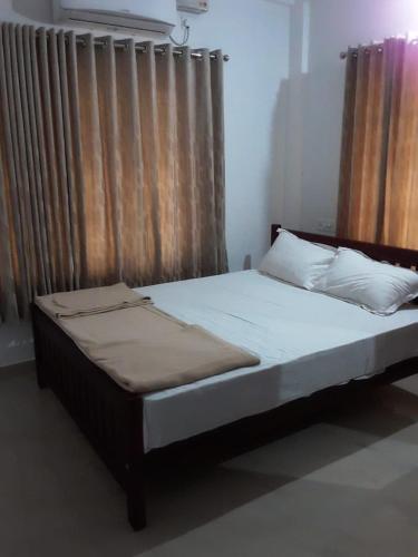 a bed with white sheets and pillows in a bedroom at Style Homes Grand Park in Elūr