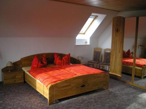 - une chambre avec un grand lit en bois et des oreillers rouges dans l'établissement Sachon Modern Retreat, à Dürrwicknitz