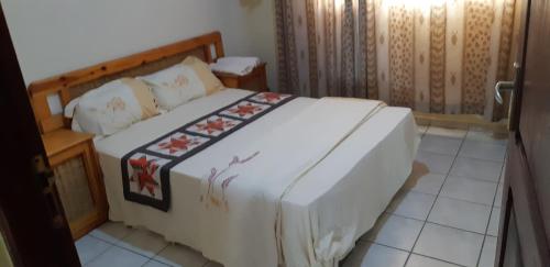 a bedroom with a bed with a wooden headboard at Férias na Praia do Tofo, relaxantes e únicas in Praia do Tofo