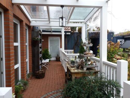 a patio with a white pergola on a house at Dollhouse Modern retreat in Wiesmoor