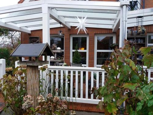 a white pergola on a house with a porch at Dollhouse Modern retreat in Wiesmoor