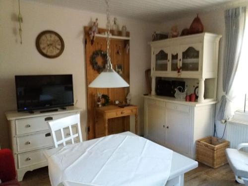 a living room with a table and a tv at Dollhouse Modern retreat in Wiesmoor