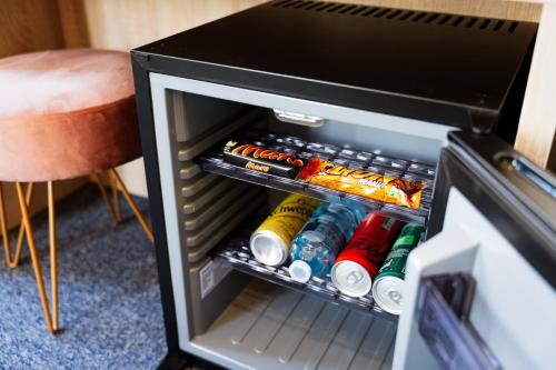 an open refrigerator door with drinks in it at Hôtel Escurial - Centre Gare in Metz