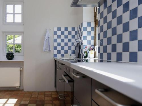 a kitchen with a sink and blue and white tiles at at the Haus Marck moated castle in Tecklenburg
