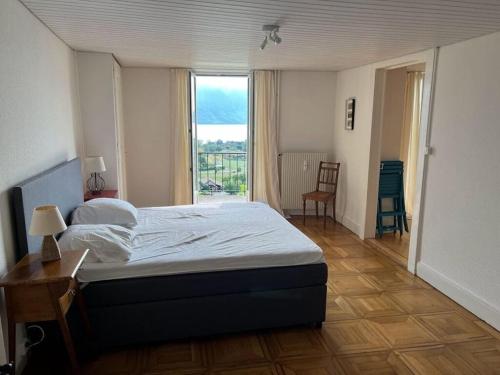 a bedroom with a bed and a large window at La Vigneronne, Lake view in Arlesheim
