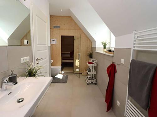 a bathroom with a sink and a staircase with a attic at Villa Ostseekind in Neuhaus