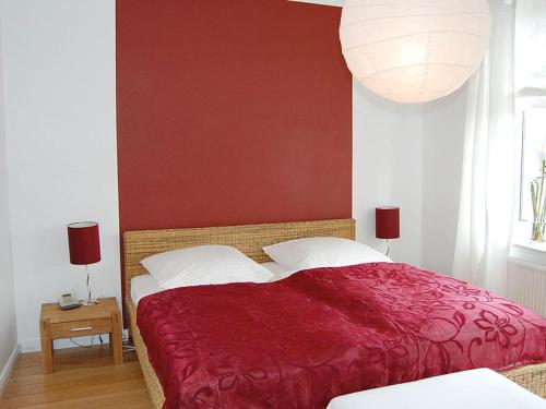 a bedroom with a large bed with a red wall at Wonen & Wellness - in Travemünde in Travemünde