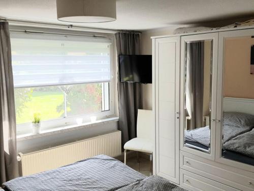 1 dormitorio con ventana y 1 cama con espejo en Lighthouse view Modern retreat, en Bastorf