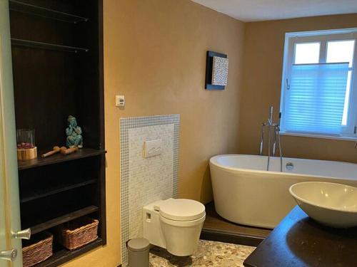 ein Badezimmer mit einer Badewanne, einem WC und einem Waschbecken in der Unterkunft Holiday home in St Martin in Sankt Martin