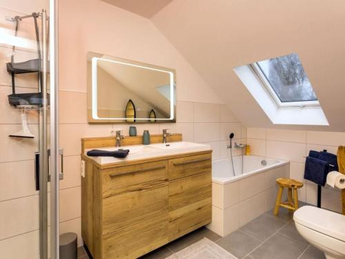 ein Badezimmer mit einem Waschbecken, einem Spiegel und einer Badewanne in der Unterkunft Dreamtime Modern Retreat in Zinnowitz