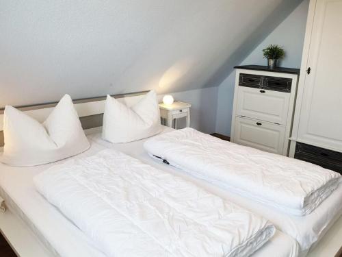 1 dormitorio con 2 camas con sábanas y almohadas blancas en Achtern Diek Modern retreat, en Brasilien