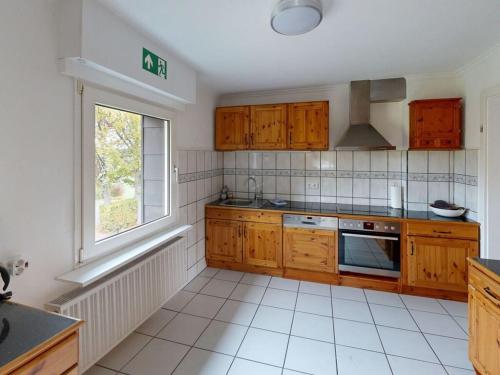 a kitchen with wooden cabinets and a window at Eifel Oasis Comfortable holiday residence in Monschau