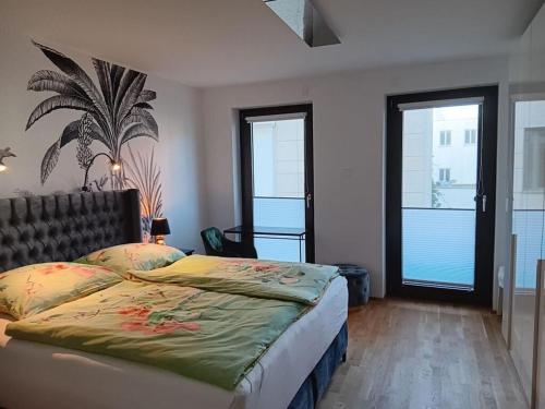 a bedroom with a large bed and two windows at City center Modern retreat in Rostock