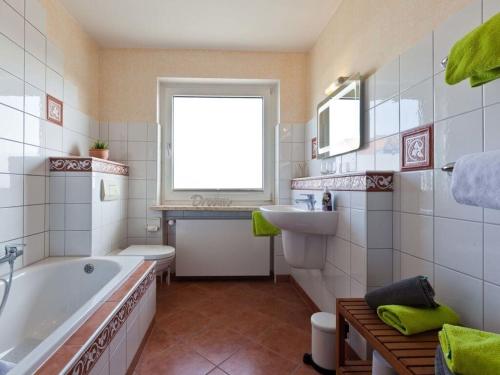a bathroom with a tub and a toilet and a sink at Charly"s Sweet Modern retreat in Norderney