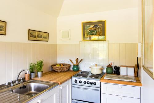 cocina con fogones y fregadero en Colmeallie Bothy - Seasgair Lodges en Brechin