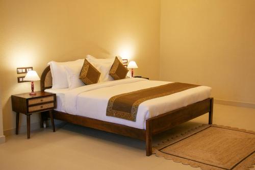 1 dormitorio con 1 cama grande con sábanas y almohadas blancas en KASHI ANANDAM SPIRITUAL & WELLNESS VEDIC VILLAGE LLP en Kakarmatha