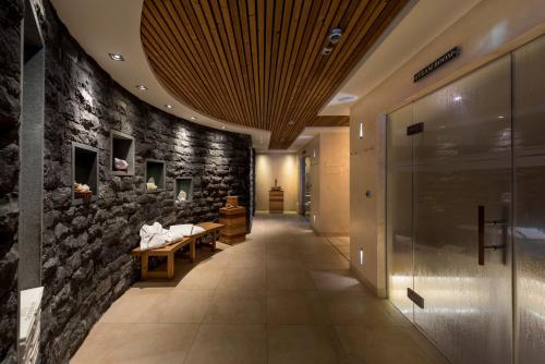 um corredor com uma parede de pedra com uma mesa e bancos em Hotel Tannenhof*****Superior em Sankt Anton am Arlberg