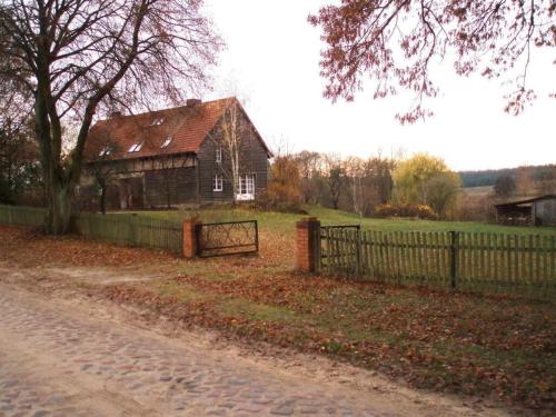 an old house in a field with a fence at Peter Lassau Modern retreat in Templin