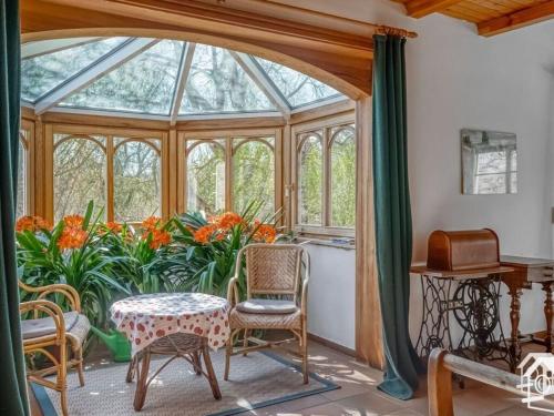 a conservatory with a table and chairs in a room at Peter Lassau Modern retreat in Templin