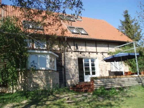 a brick house with an umbrella in front of it at Peter Lassau Modern retreat in Templin