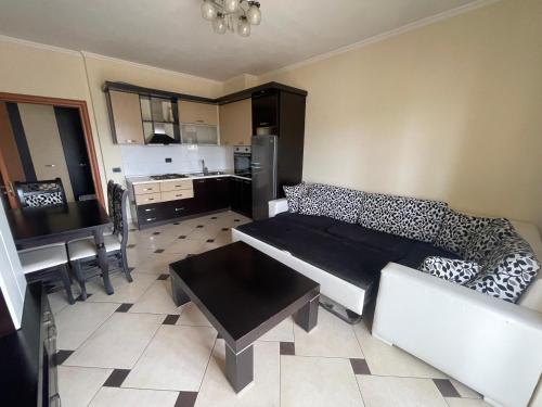 uma sala de estar com um sofá e uma cozinha em Quality Apartaments em Durrës