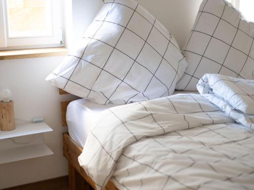 um quarto com uma cama com lençóis brancos e almofadas em Concordia33 Modern retreat em Bamberg