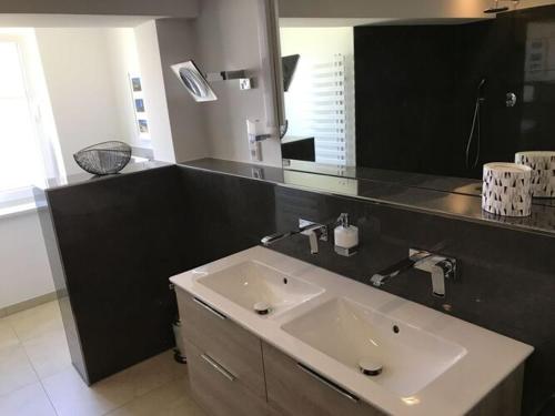 ein Badezimmer mit einem Waschbecken und einem großen Spiegel in der Unterkunft Villa Bi de cooling in Neu Gaarz