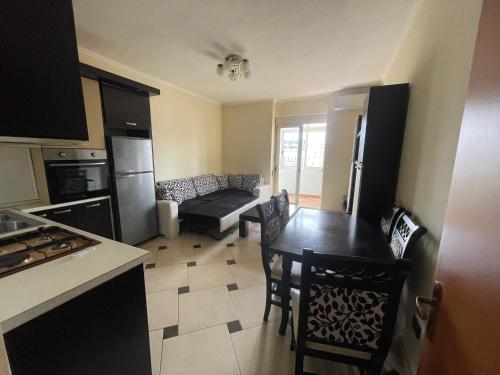 uma cozinha e sala de estar com uma mesa e um sofá em Quality Apartaments em Durrës