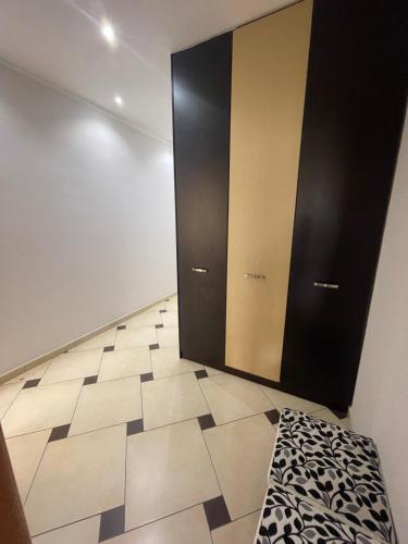 um quarto com portas pretas e piso em azulejo em Quality Apartaments em Durrës