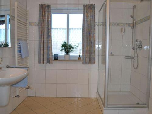y baño con ducha y lavamanos. en Haus Jörg Sosna Modern retreat en Bayersoien
