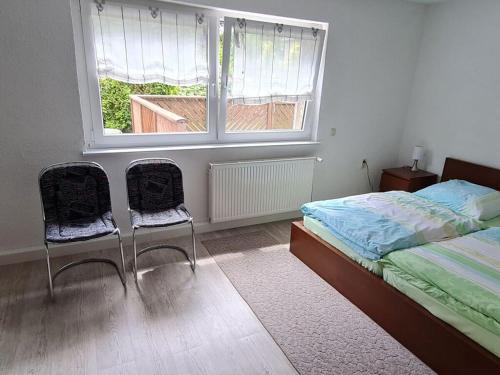 1 dormitorio con 1 cama, 2 sillas y ventana en Bräuer Modern retreat, 