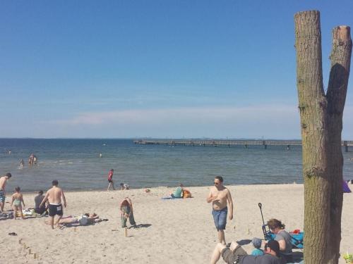 a group of people on a beach near the water at to the beach Comfortable holiday residence in Lubmin