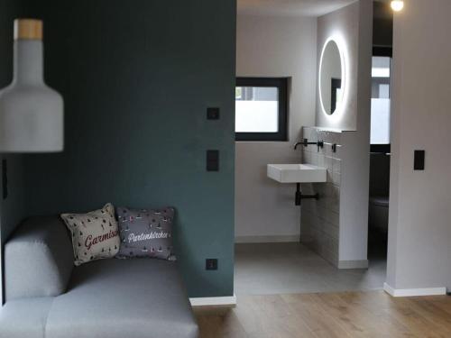 加爾米施－帕騰基興的住宿－Griabig Lodge Modern retreat，一间带沙发的盥洗盆旁浴室