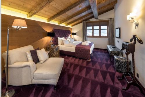 een hotelkamer met 2 bedden en een bank bij Hotel Tannenhof*****Superior in Sankt Anton am Arlberg