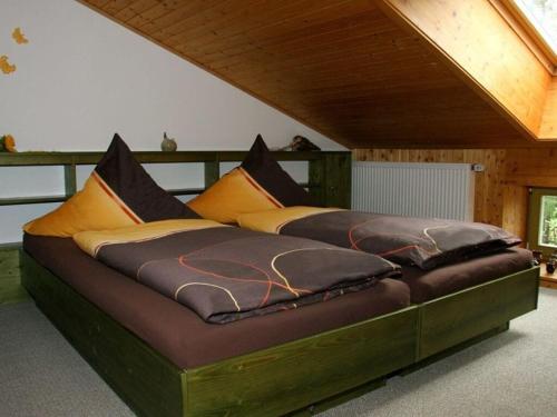 ein großes Bett in einem Zimmer mit einem Holzrahmen in der Unterkunft Ms Monika Rasehorn in Rehefeld-Zaunhaus