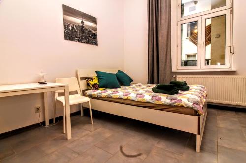 a bedroom with a bed and a desk and a window at Stradomska 5, apartment Chopin in Krakow