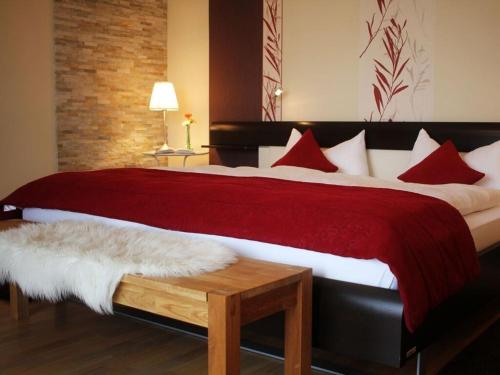 a bedroom with a large bed with red and white pillows at Kiesenberg 9 Modern retreat in Thanstein