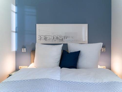 1 dormitorio con 1 cama con sábanas y almohadas blancas en Beach house Dune 19 - Joy en Neuhaus