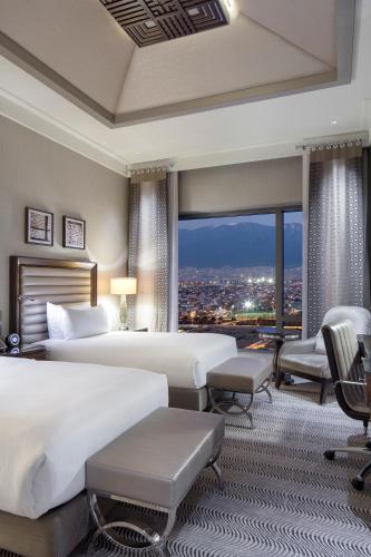 a bedroom with two beds and a view of a city at Hilton Bursa Convention Center & Spa in Bursa
